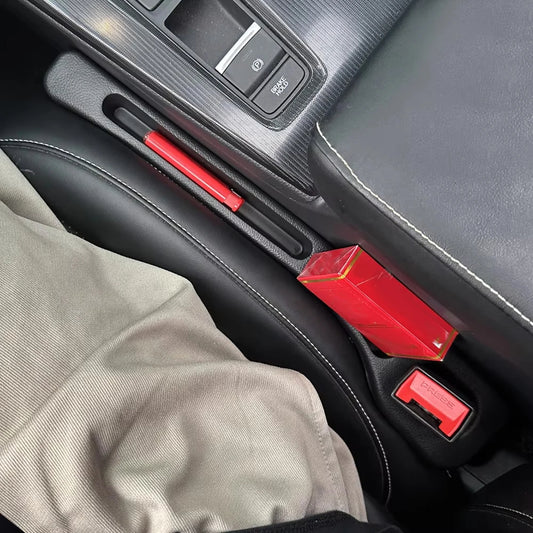 Red carabiner attached to a car's door handle and dashboard.