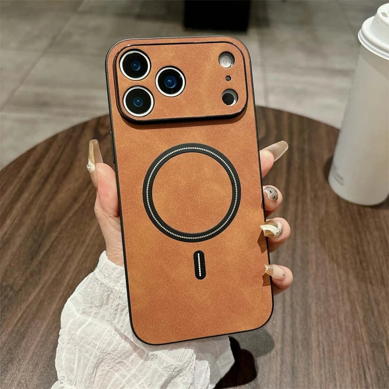 Hand holding a brown phone case with a circular design on a wooden table.