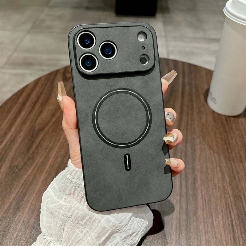 Person holding a black phone case with a circular design on a wooden surface.